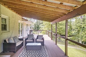 A covered porch with wicker furniture and a patterned rug. - Fayetteville Fall Getaway | Family & Pet Friendly (Fayetteville)