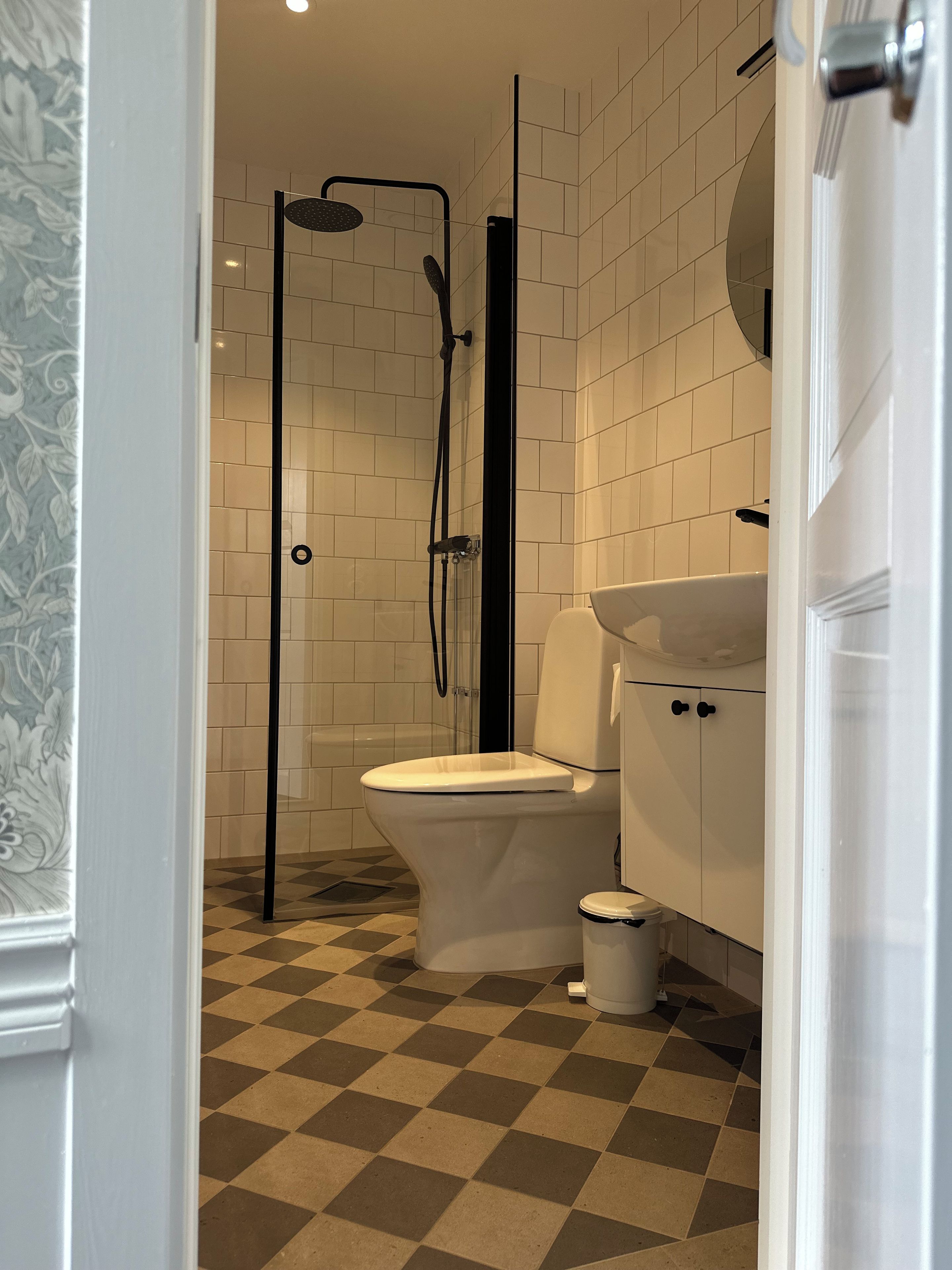 A bathroom with a shower, toilet, and sink.