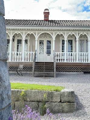 A building with a white facade, multiple windows, and a central door.