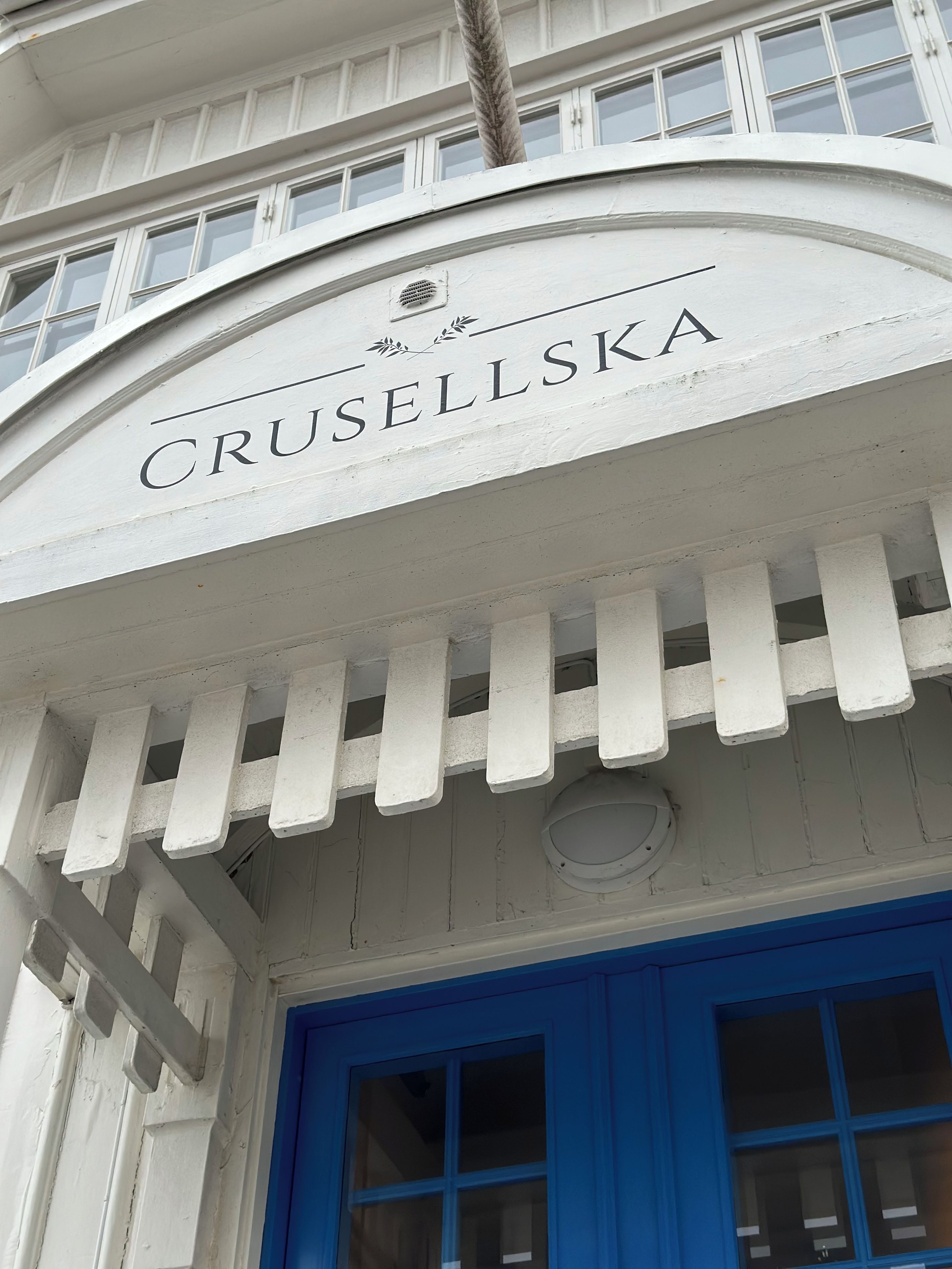 Un edificio con un letrero que dice 'CRUSELLSKA' sobre una puerta azul.