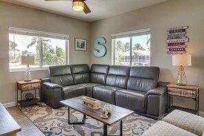 A living room with a sectional sofa, a coffee table, a lamp, and a wall with motivational signs. - Private Dock & Pool: Waterfront Key Largo Home (Key Largo)