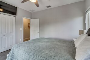 A bedroom with a bed, a door, a ceiling fan, and a window. - Private Dock & Pool: Waterfront Key Largo Home (Key Largo)