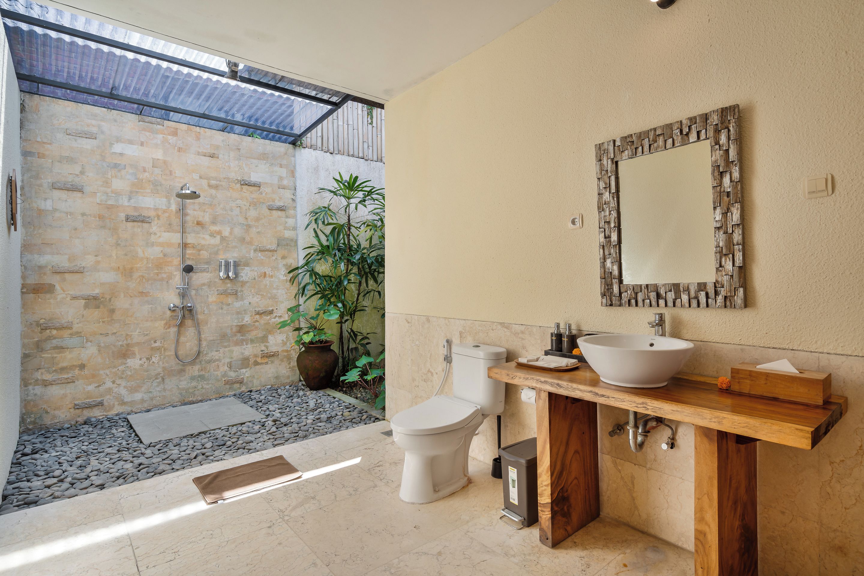 Un baño con ducha, inodoro, lavamanos y espejo.