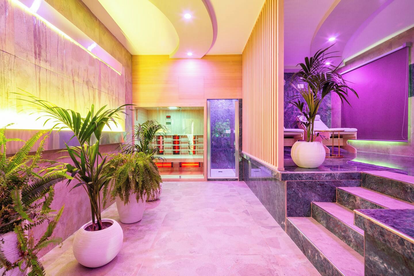 Una hall moderna con pavimento in marmo, grandi piante in vaso e una reception.