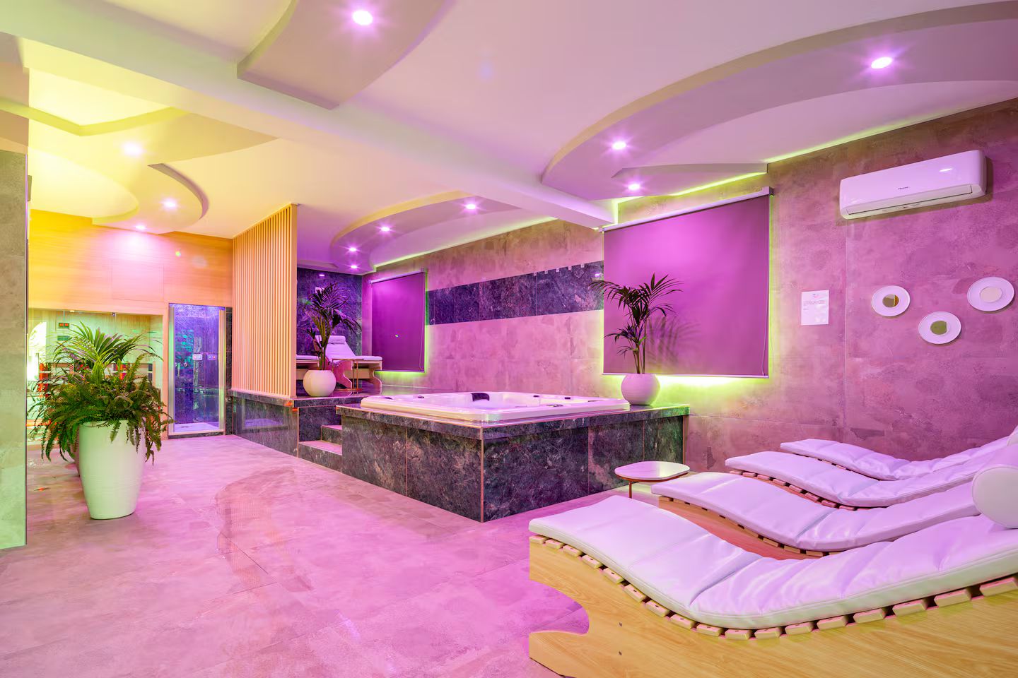 Ein moderner Spa-Bereich mit Massageliege, einer Rezeption und einer großen Pflanze in einem Topf.