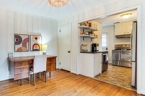 A kitchen with white cabinetry, a wooden dining table, and a modern pendant light. - 9 Mi to Dtwn Nashville! Updated Home + Large Yard (Nashville)
