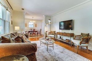 A living room with a sofa, coffee table, TV, and a dining area with chairs and a table. - 9 Mi to Dtwn Nashville! Updated Home + Large Yard (Nashville)