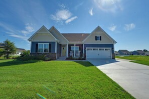 A two-story house with a garage, a front porch, and a well-maintained lawn. - Stylish Waterfront Home w/ Views in Lewes! (Lewes)