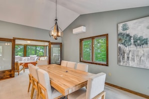 A dining area with a wooden table, chairs, and a chandelier. - Spacious, Modern! Wintergreen Resort Ski Retreat (Nellysford)
