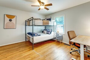 A room with a bunk bed, a desk, a chair, a ceiling fan, and a window with blinds. - Commute to ATL! Home Near Canton St Eats (Roswell)