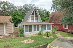 A residential house with a gabled roof, a front porch, and a small front yard with a palm tree and shrubs. - Pool Access! 'The Palmetto House' in Clermont (Clermont)