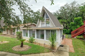 A residential house with a gabled roof, large windows, and a small front yard with a palm tree and a brick pathway leading to the entrance. - Pool Access! 'The Palmetto House' in Clermont (Clermont)