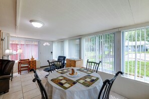 A dining area with a round table, chairs, and a view of the outdoors through large windows. - Pool Access! 'The Palmetto House' in Clermont (Clermont)