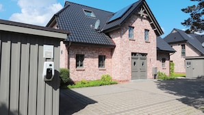 Ein Wohngebäude mit Backsteinfassade, Ziegeldach und geschlossenem Eingang.