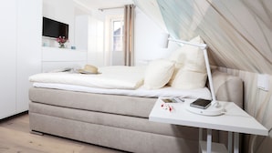 Ein modernes Schlafzimmer mit einem Bett, einem Nachttisch und einem Fenster.