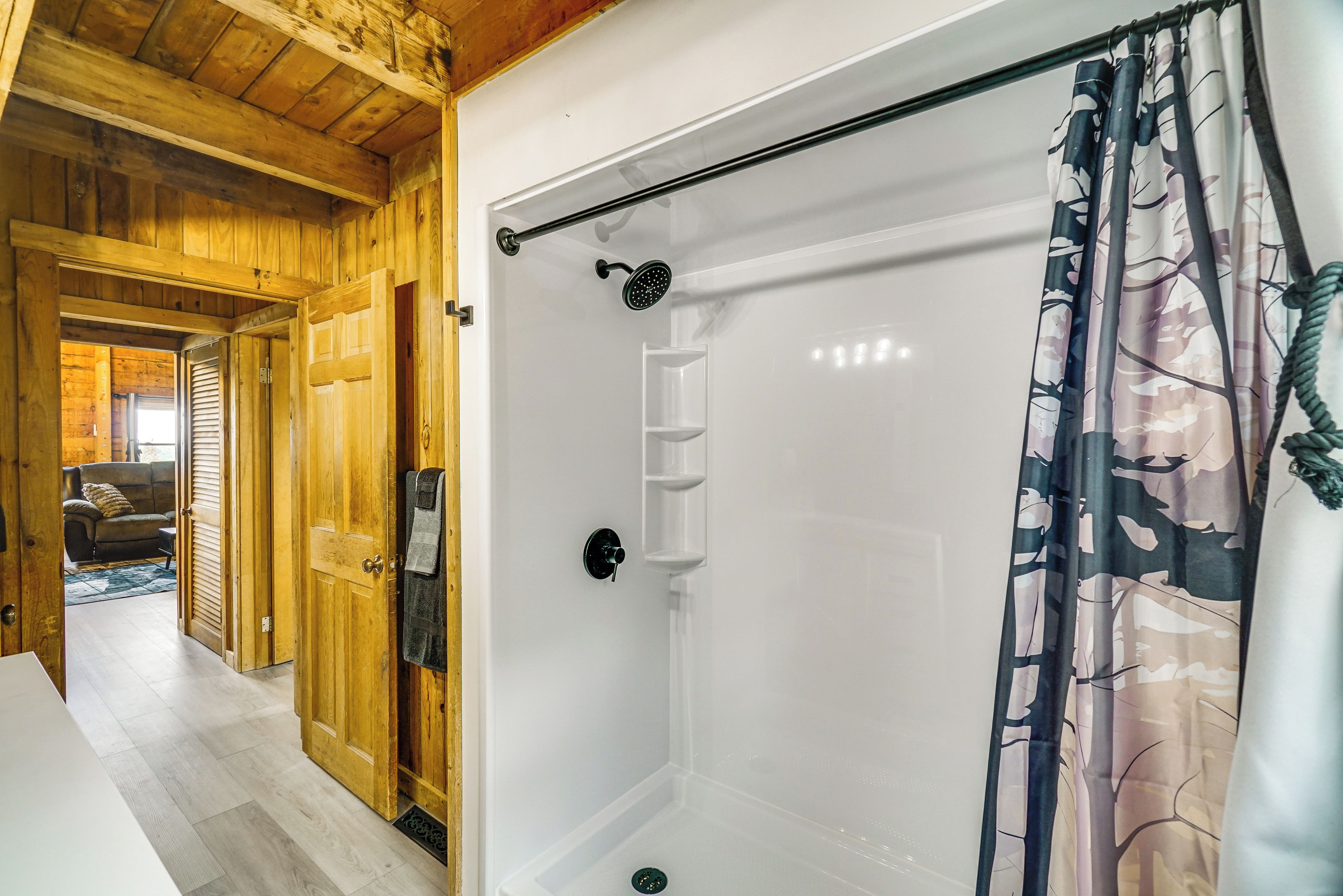 A shower with a glass door, a towel rack, and a showerhead.