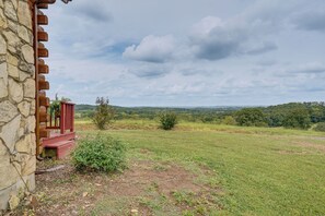 Ein Steinhaus mit einer roten Struktur und Blick auf eine grüne Landschaft.