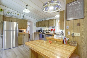 A kitchen with wooden cabinets, stainless steel appliances, a wooden island, and a chalkboard with measurements. - Rural Home Close to Hot Springs & 4 Ski Resorts (New Castle)