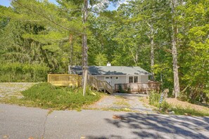 A cabin with a deck, surrounded by dense forest. - Massanutten Resort Home w/ Hot Tub & Game Room! (McGaheysville)