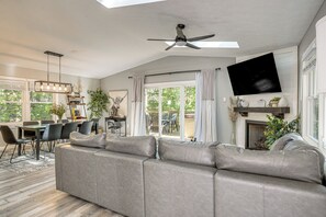 A modern living room with a sectional sofa, dining area, and a fireplace. - Massanutten Resort Home w/ Hot Tub & Game Room! (McGaheysville)