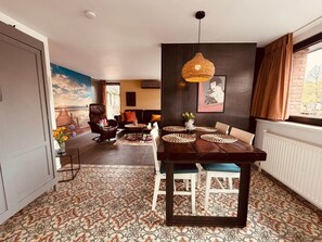 A dining area with a dark wooden table, woven placemats, and a hanging light fixture. - Bunga Vijverzicht (Bunga holidays) (Lanaken)