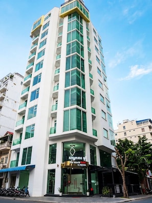 Ein mehrstöckiges Hotel mit modernem Design, das durch einen markanten Eingangsbereich mit der Aufschrift 'The Movie Hotel by MECON' gekennzeichnet ist.