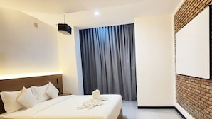A hotel room with a large bed, a flat-screen TV mounted on the wall, and a projector on the ceiling. - The Movie Hotel by Mecon (Phnom Penh)