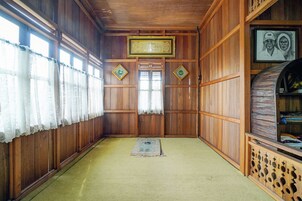 Una habitación con paneles de madera, un tapete de oración y un cuadro enmarcado en la pared.