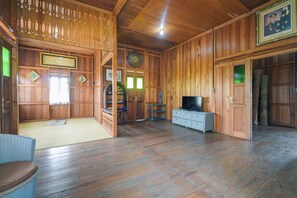 A traditional wooden interior with a television, shelves, and a clock.