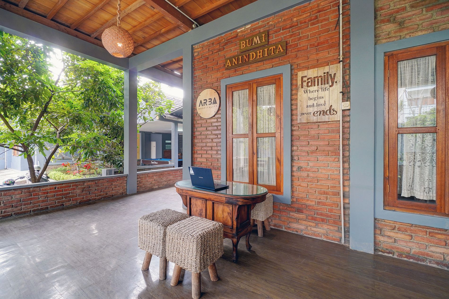 Una habitación con estructura de madera y un letrero que dice 'BUMI ANINDHITA' y 'Hospitalidad'.