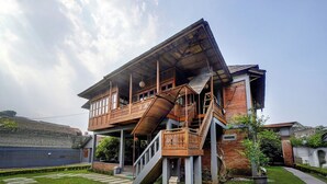 Een huis met twee verdiepingen, een balkon, een trap en een tuin.