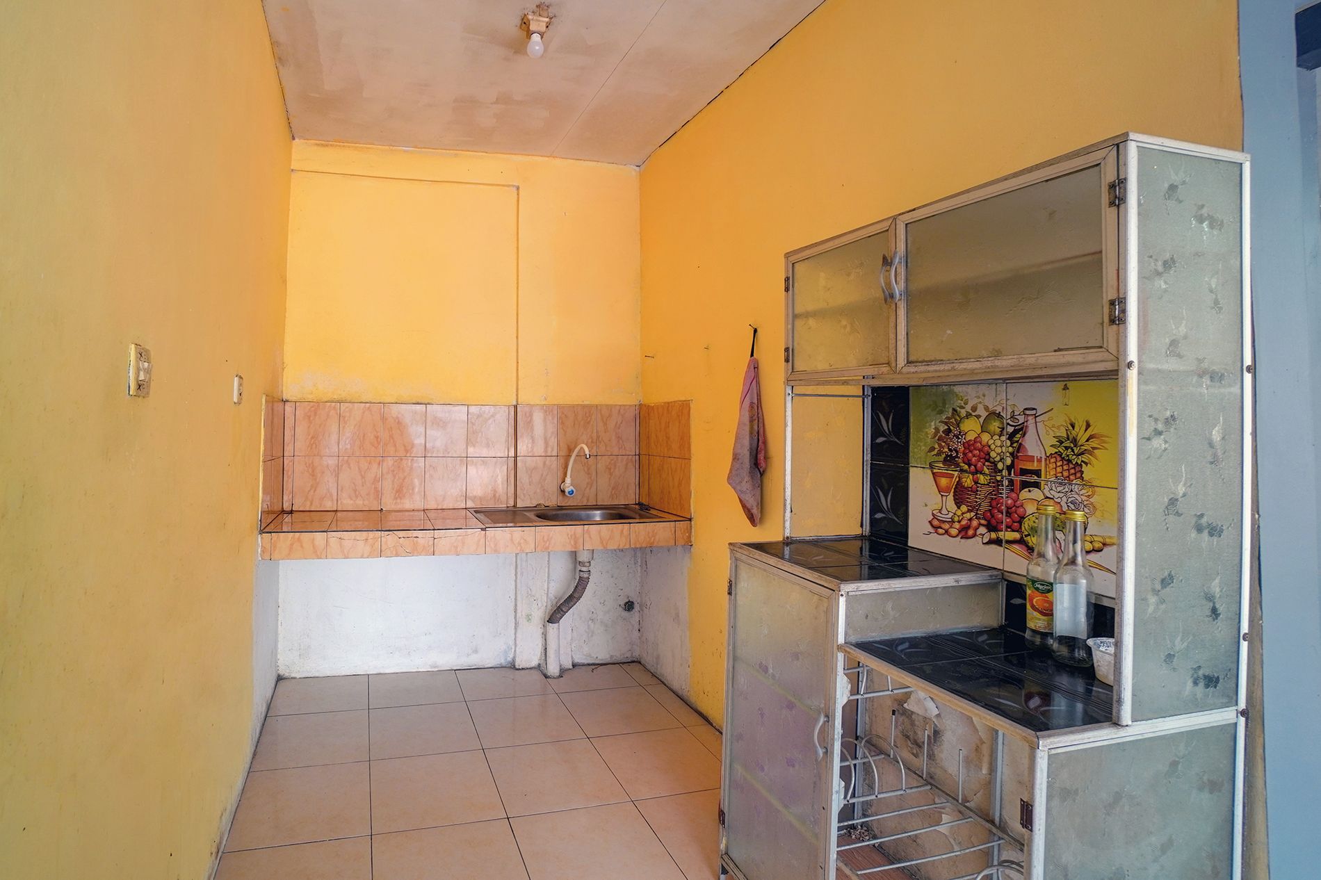 Cozinha compacta com pia, bancada e geladeira.
