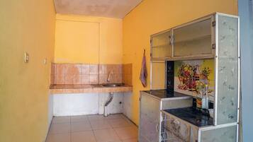 Cozinha compacta com pia, bancada e geladeira.
