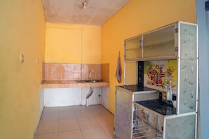 Una cocina compacta con un lavamanos, una encimera y un refrigerador.