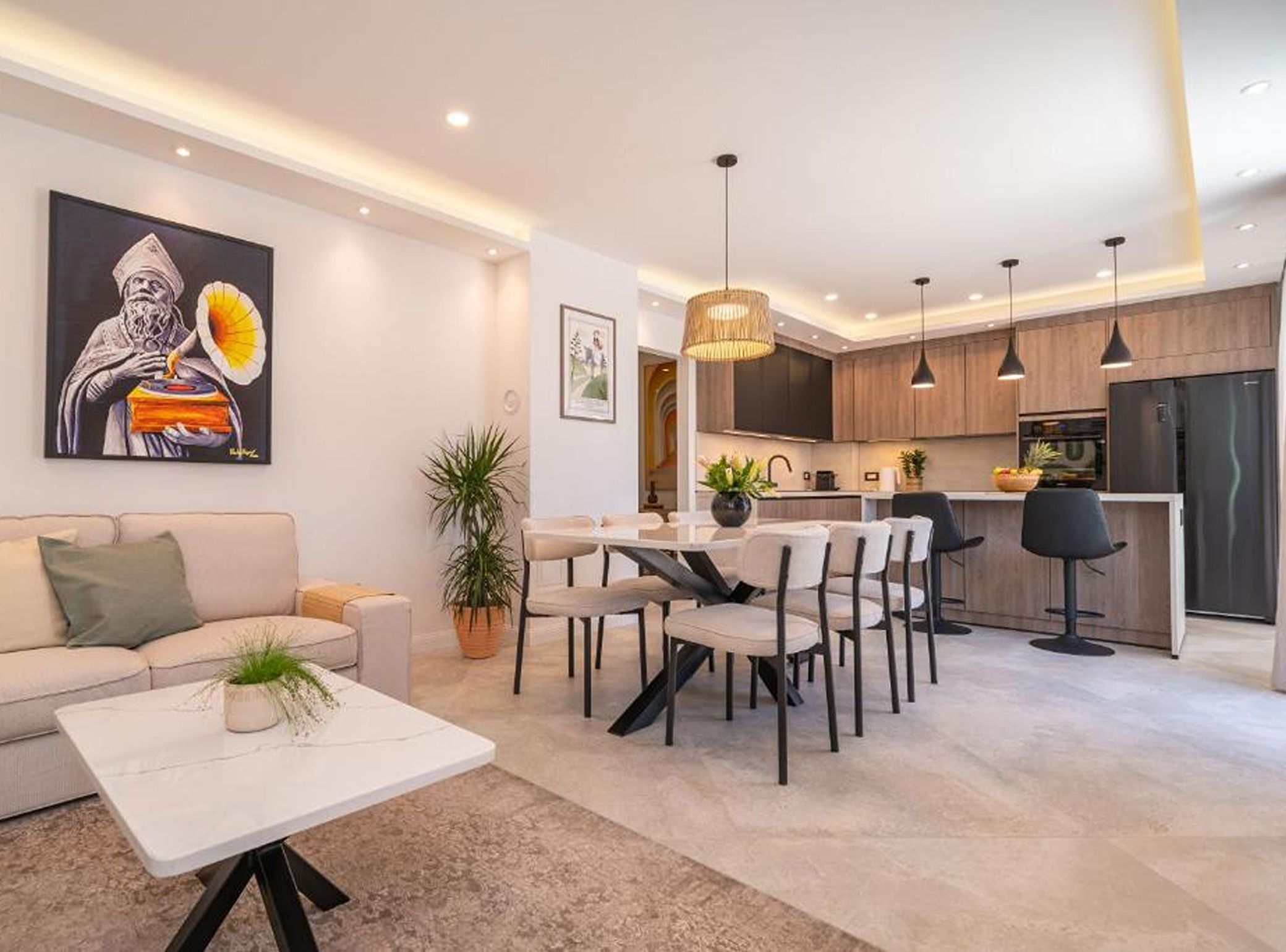 A modern living room with a sofa, coffee table, and dining area with chairs.