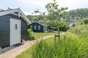 En byggnad med en dörr och en liten uteplats med ett bord och några stolar.