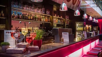 Una zona de bar con estanterías llenas de botellas, una barra con vasos y un cartel con un número.