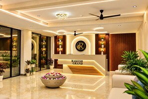 A modern reception area with a marble floor, a reception desk, and a ceiling fan. - Hotel Rakesh Grand Hyderabad (Hyderabad)