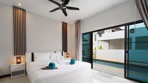 Een moderne hotelkamer met een groot bed, een plafondventilator, een nachtkastje met een lamp en uitzicht op een zwembad door een glazen deur.