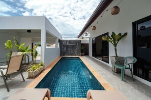 A modern outdoor swimming pool with a clear blue water surface, surrounded by white walls and potted plants. - Elyana Villa -3BR Oasis in Rawai (Tambon Rawai)