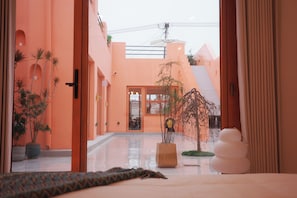 A hotel corridor with a view of the entrance, potted plants, and a staircase leading to the upper floors. - Rons Wizardry Healing Homestay (Tongzhou)