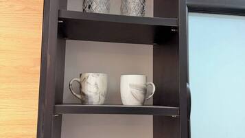 A black shelf with three tiers, each holding different items.
