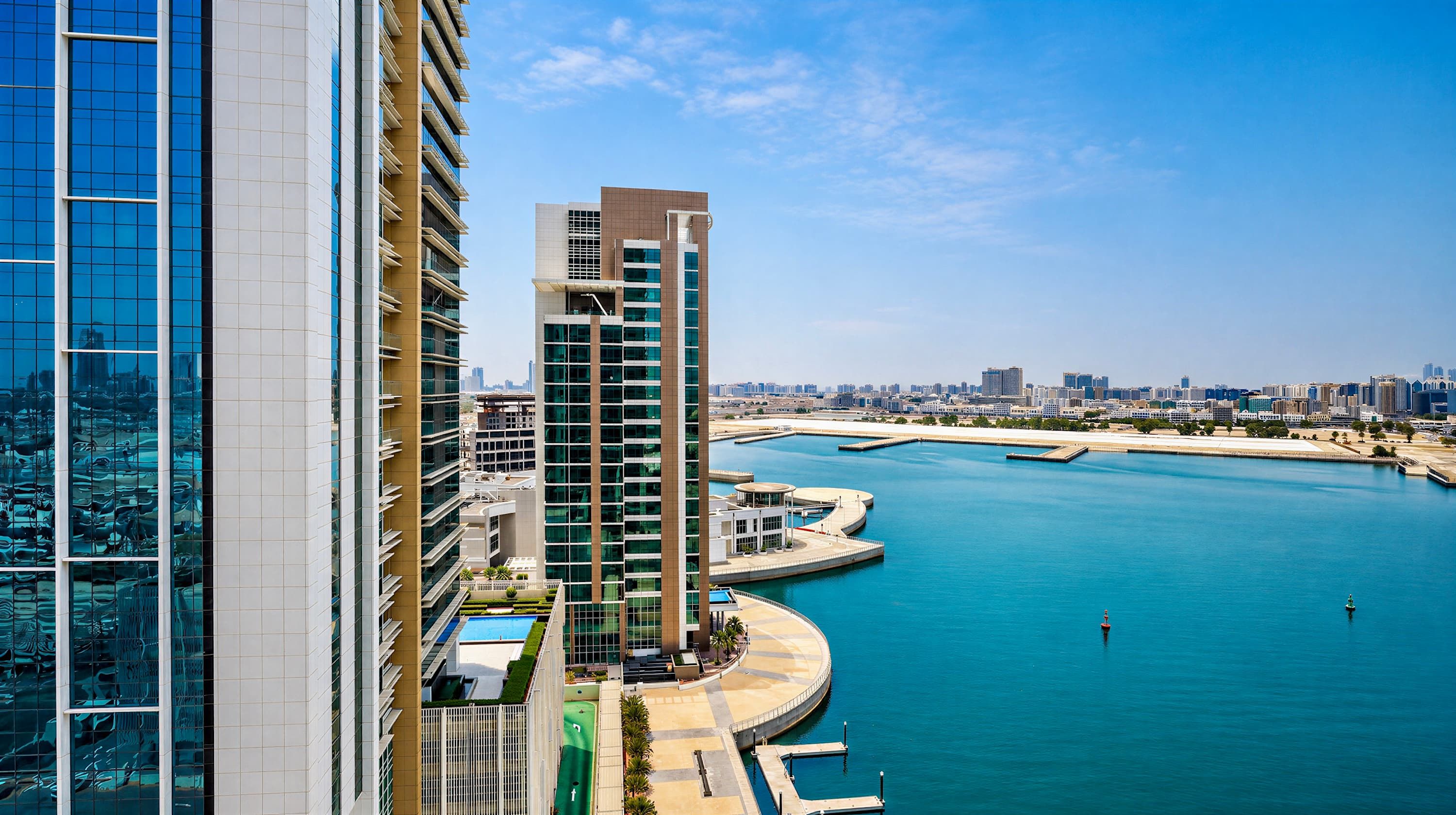 Ein Hochhaus mit Blick auf das Wasser, einschließlich eines Yachthafens und einer Stadtansicht im Hintergrund.