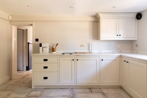 Eine moderne Küche mit weißen Schränken, einer Marmorarbeitsplatte und einem eingebauten Backofen.