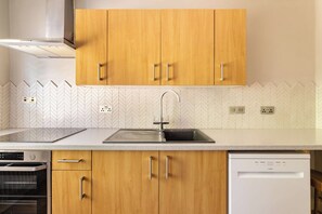 A kitchen with wooden cabinets, a stainless steel sink, and a dishwasher. - Country House with Pool, Cinema & Tennis Court (Rougham)