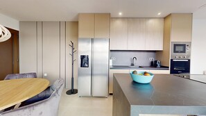 A modern kitchen with a built-in refrigerator, a coffee machine, and a microwave. - Villa Almoradi 6P - Pool - Jacuzzi (Almoradí)