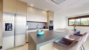 A modern kitchen with a central island, stainless steel appliances, and a view of the outdoors. - Villa Almoradi 6P - Pool - Jacuzzi (Almoradí)