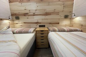 A bedroom with two beds, wooden headboard, bedside lamps, and a small wooden dresser. - Holiday home with 2 bedrooms (Bruinisse)