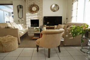 Ein Wohnzimmer mit Kamin, Fernseher und zwei Sofas.