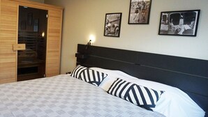 Un dormitorio con una cama, un armario de madera y tres fotografías enmarcadas en la pared.